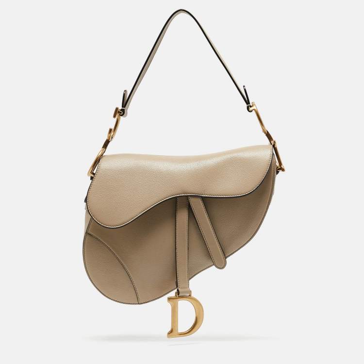 Close-up of Dior Saddle Bag strap and logo detail – premium craftsmanship and iconic branding on women’s fashion accessory.
