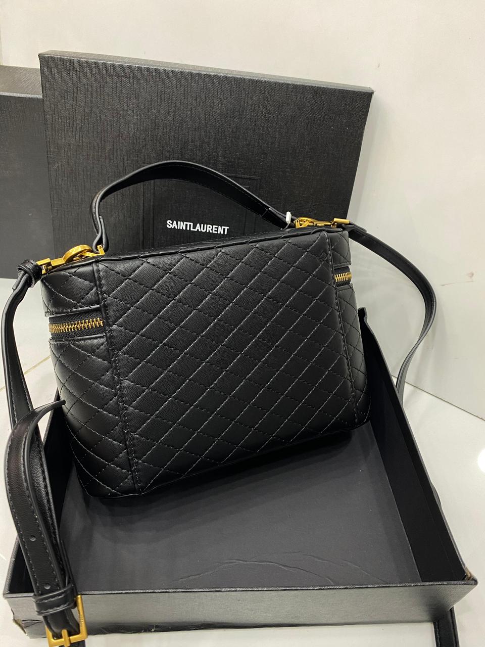 Angled view of GABY vanity bag by Saint Laurent – structured lambskin bag with luxurious quilted texture and top handle.