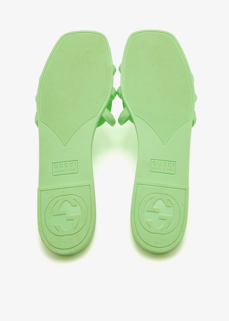 Close-up of Gucci Mystic sandal strap in green – embossed logo and textured rubber finish for modern appeal.