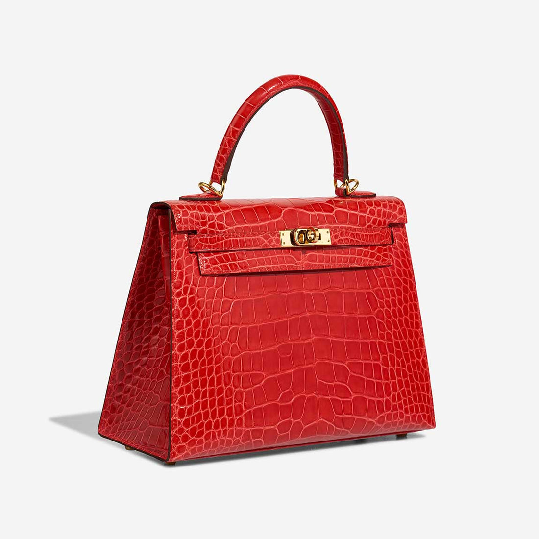 Front view of Hermès Kelly 25 in red crocodile leather with gold hardware, showing classic structured shape and top handle.