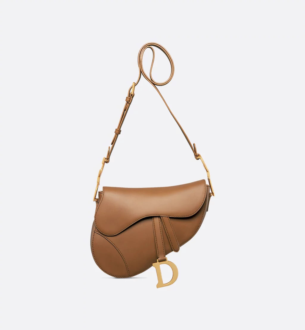 Classic black Dior Saddle Bag featuring structured shape, antique gold hardware, and shoulder strap