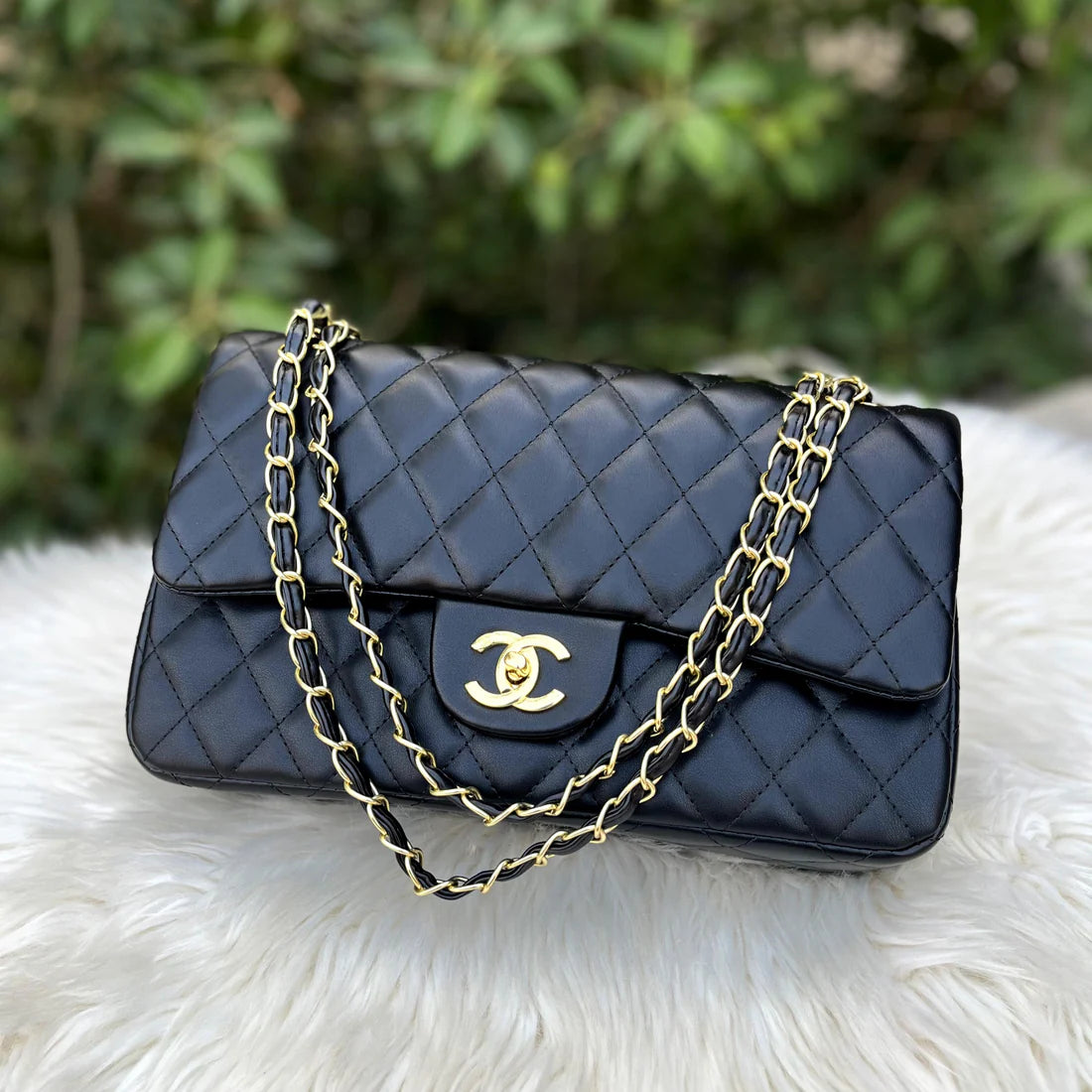 Close-up of CHANEL Classic Double Flap Bag, showcasing the iconic black quilted leather and gold hardware.