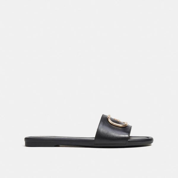 Model wearing Coach Evy Sandals – stylish women’s footwear perfect for summer outings and everyday fashion looks.
