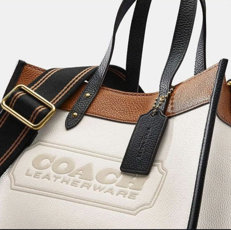 Coach Field Tote 22 in Colorblock, a modern and functional handbag with the iconic Coach badge.