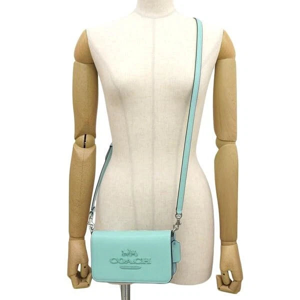 Side profile of blue Coach Tony Crossbody Bag showing adjustable strap and compact size