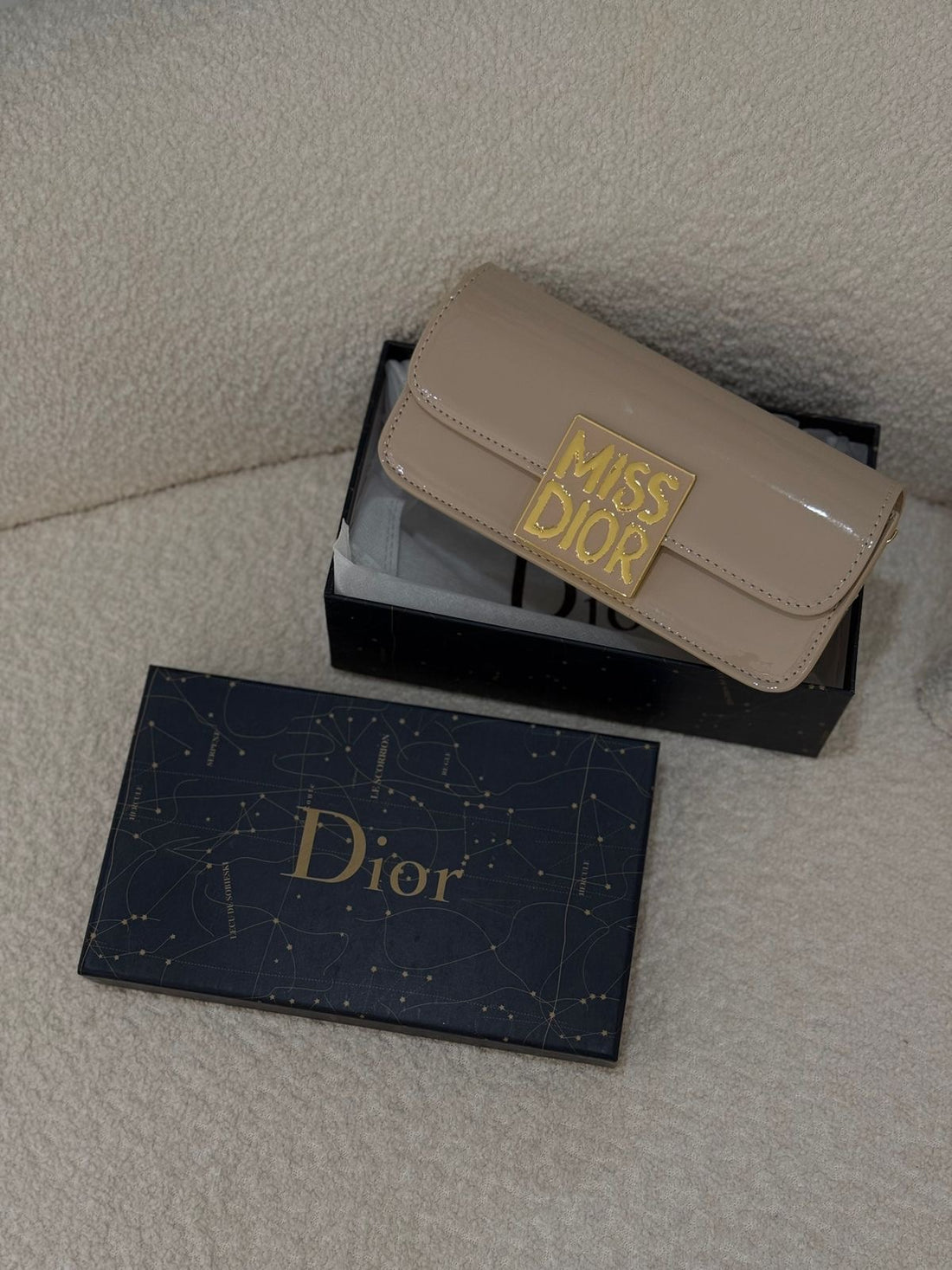 Model carrying Dior patent leather calfskin shoulder bag – perfect designer accessory for formal and high-fashion looks.