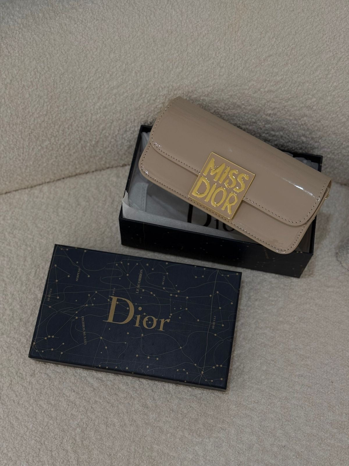 Top view of Dior patent leather handbag – showcasing double handles, smooth zip closure, and polished calfskin texture.