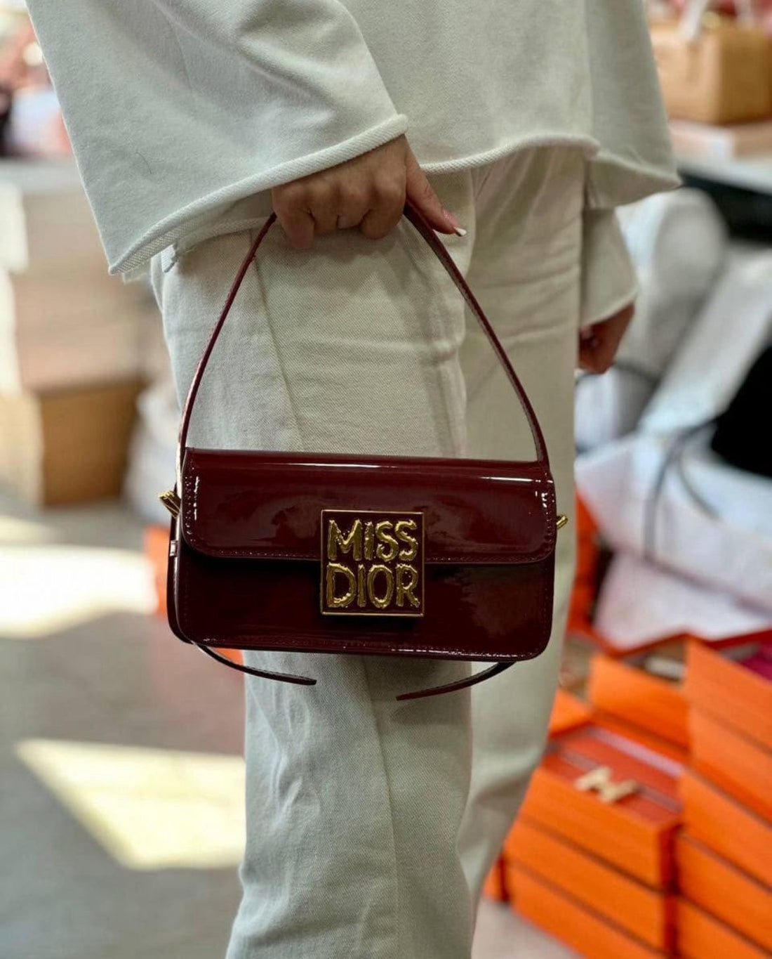 Model carrying Dior patent leather calfskin shoulder bag – perfect designer accessory for formal and high-fashion looks.