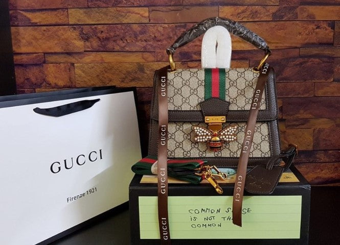 Black GUCCI Queen Margaret handbag crafted from premium leather, featuring gold-tone hardware and signature bee motif.