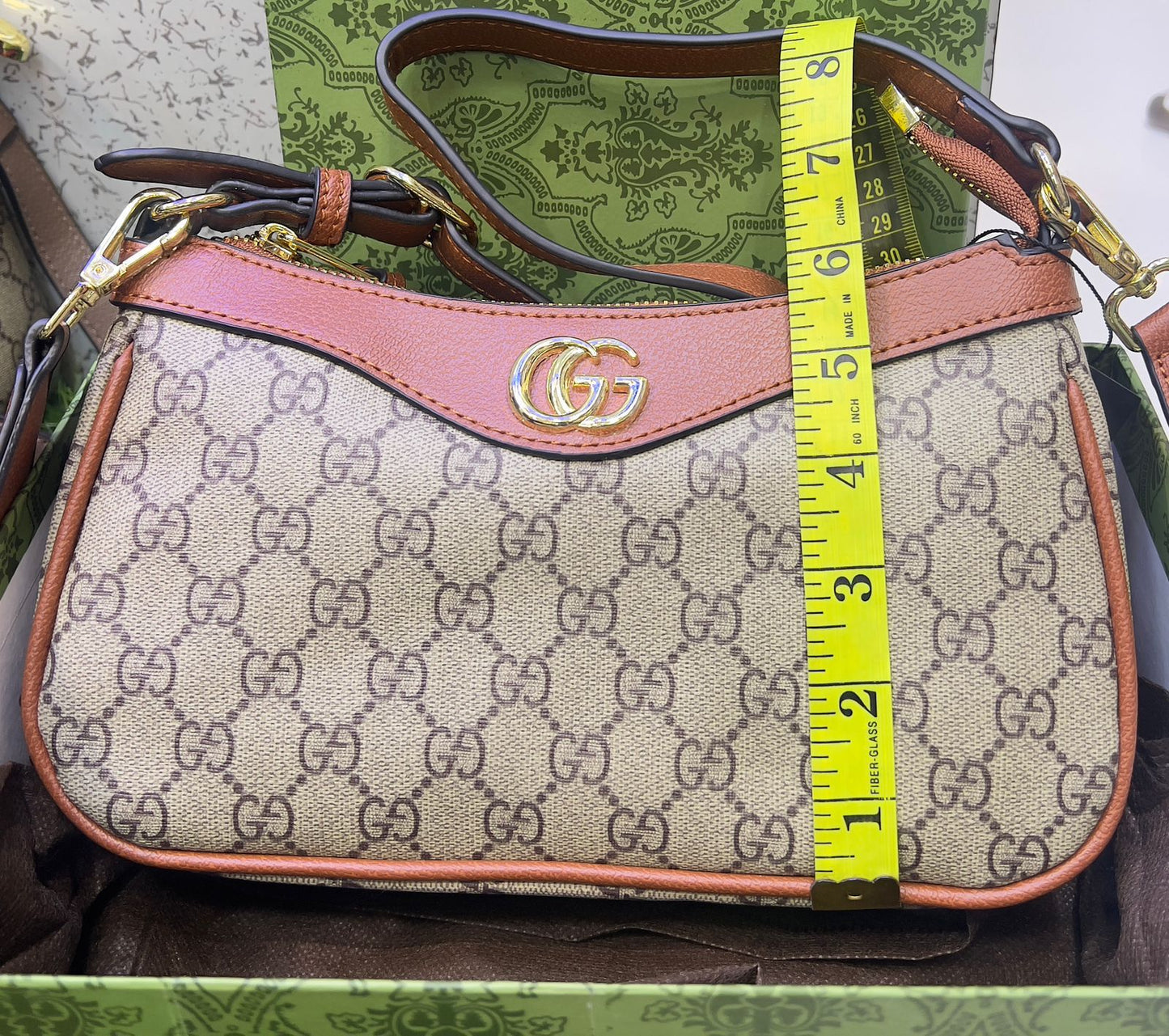 Detail shot of Gucci Luxe Stylish Handbag in beige, pink, and brown, featuring the iconic Gucci logo and luxe hardware.