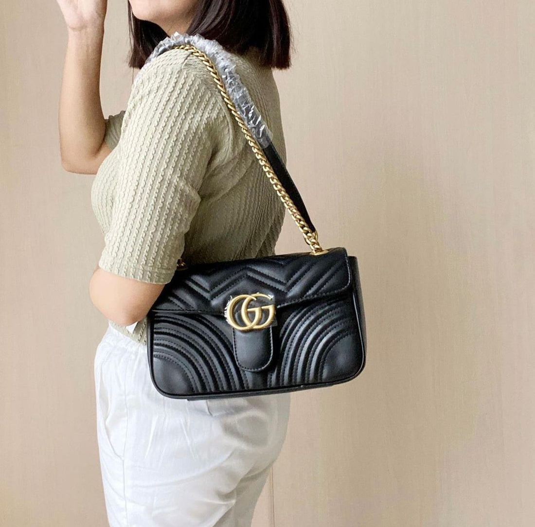 Black Gucci Marmont Shoulder Bag with soft matelassé leather and adjustable chain shoulder strap.

