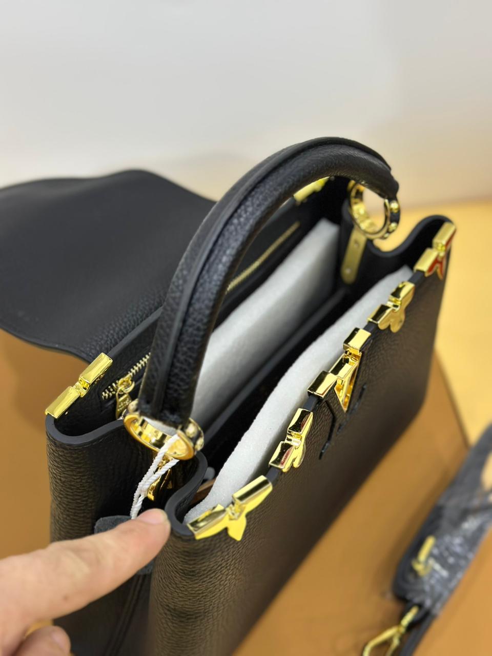 Side angle of Louis Vuitton handbag – premium monogram leather design with gold-tone hardware for timeless fashion.