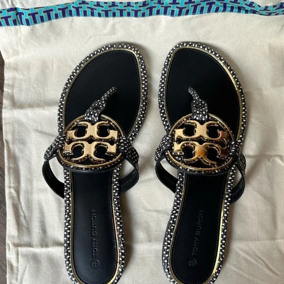 Brown leather flat sandals with gold emblem chain detai