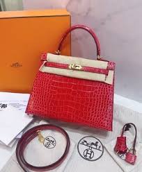 Front view of Hermès Kelly 25 in red crocodile leather with gold hardware, showing classic structured shape and top handle.