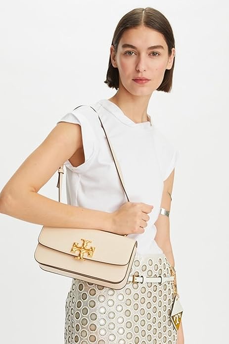 Close-up of Tory Burch Britten logo and adjustable strap – premium detailing on a luxury women's shoulder bag.