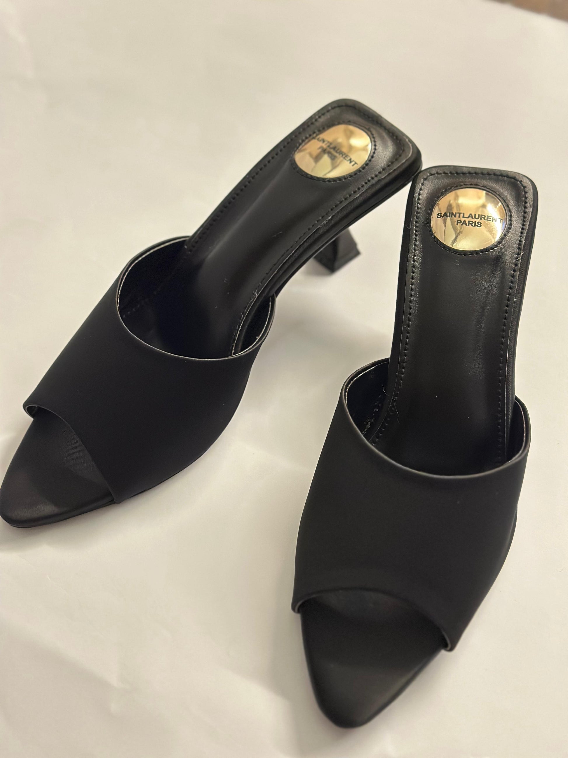 Model wearing YSL black slide heels – high-fashion women’s footwear perfect for both formal and evening outfits.