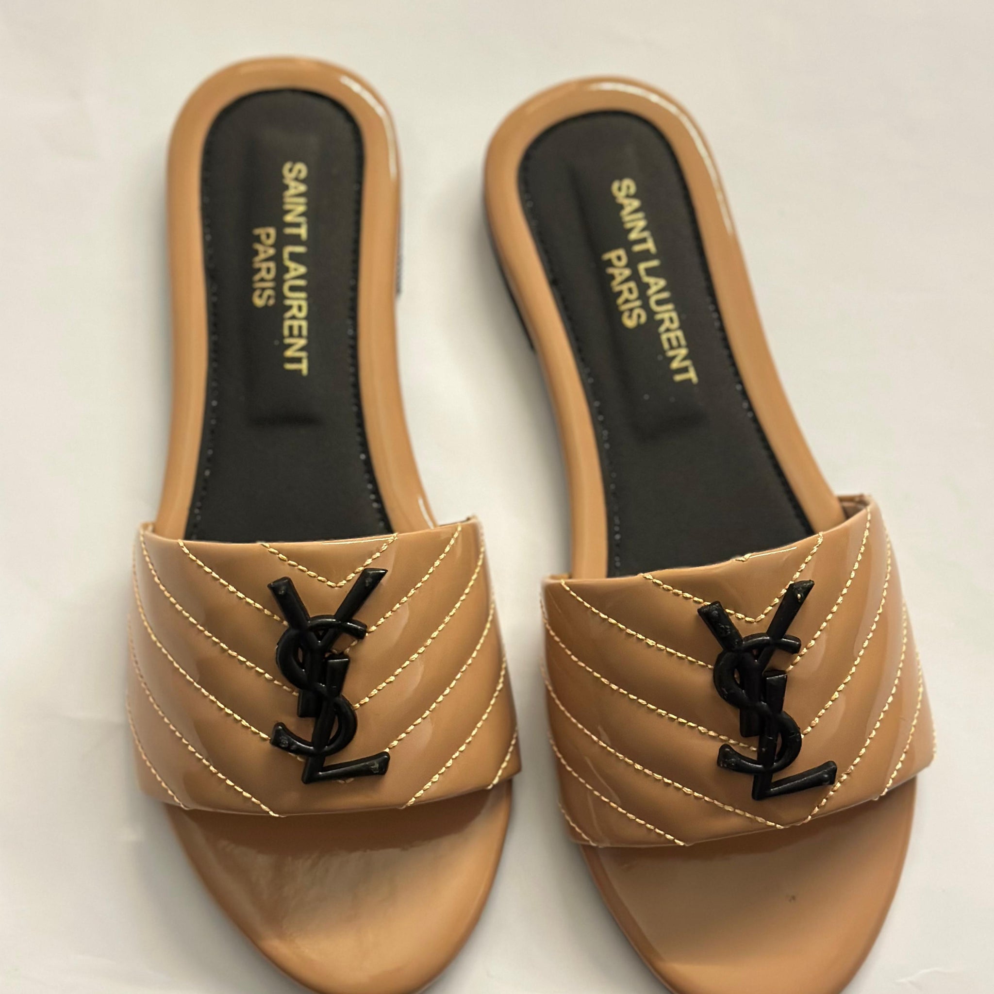 Front view of YSL flat slides – luxury women’s sandals with signature YSL logo and minimalist leather design.