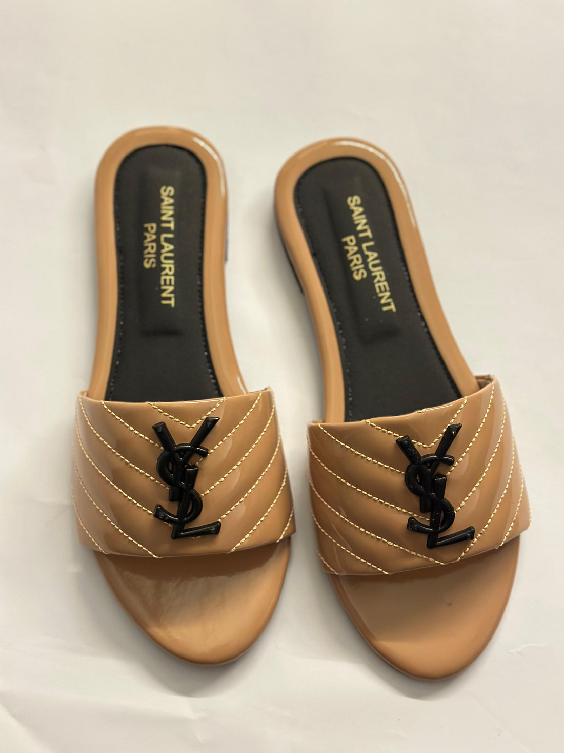 Front view of YSL flat slides – luxury women’s sandals with signature YSL logo and minimalist leather design.